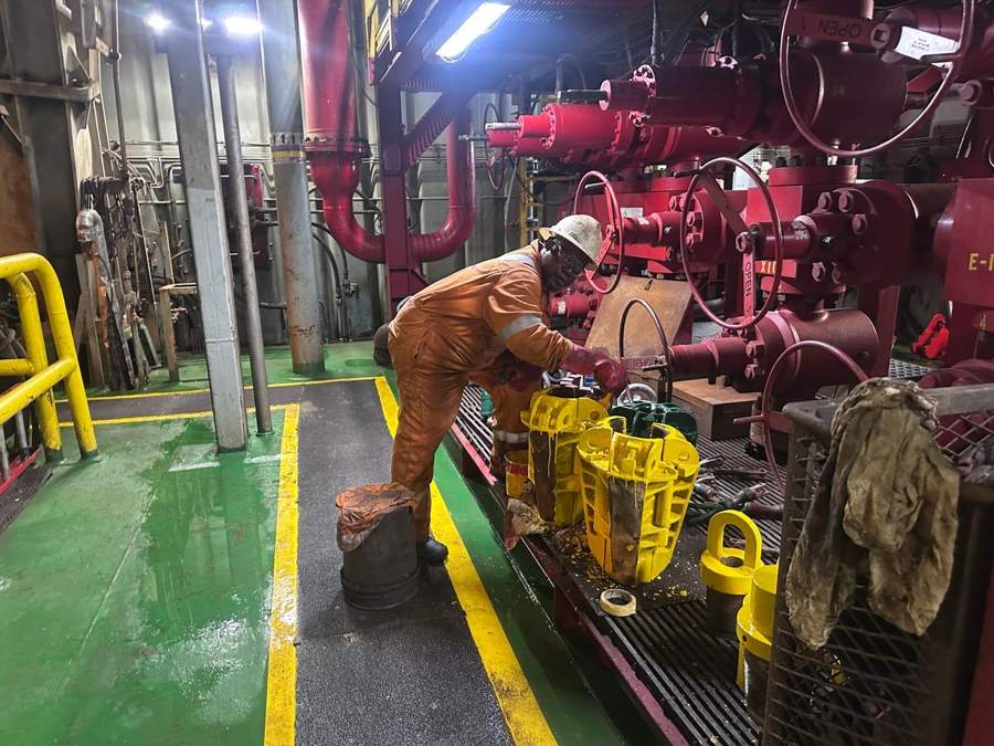 Rig floor crew servicing drilling slips